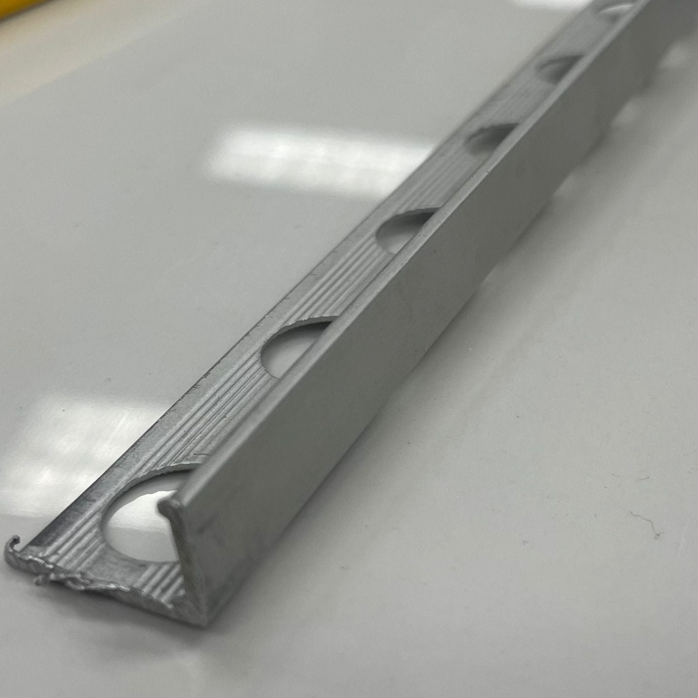 Chrome coloured matte aluminum tile moulding/trim with a 1/2" or 3/8" thickness.