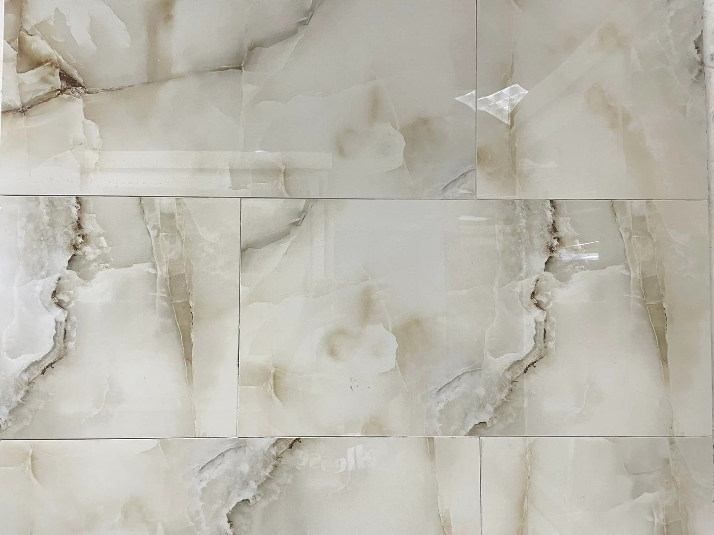 Anty Sky Ivory polished porcelain tile with a beige onyx design, for floors and walls. In a 12x24" size.