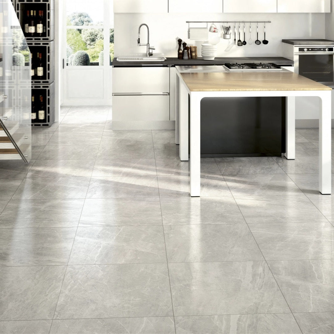 Athena Grigio matte porcelain tile with a grey stone design, for floors and walls. Made in Italy, installed in a room.