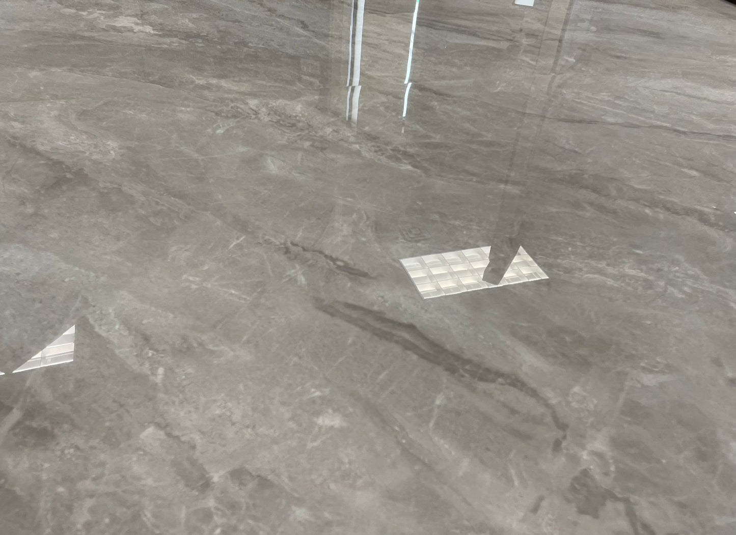 Avalon polished porcelain tile with a grey stone effect, for floors and walls. A close up of the tile.