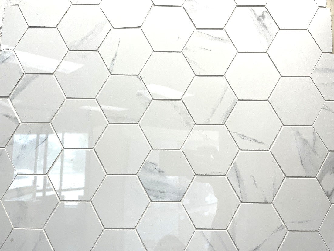 Calacatta Argento polished porcelain mosaic with a white marble design, for floors and walls. In a 5" hexagon size.