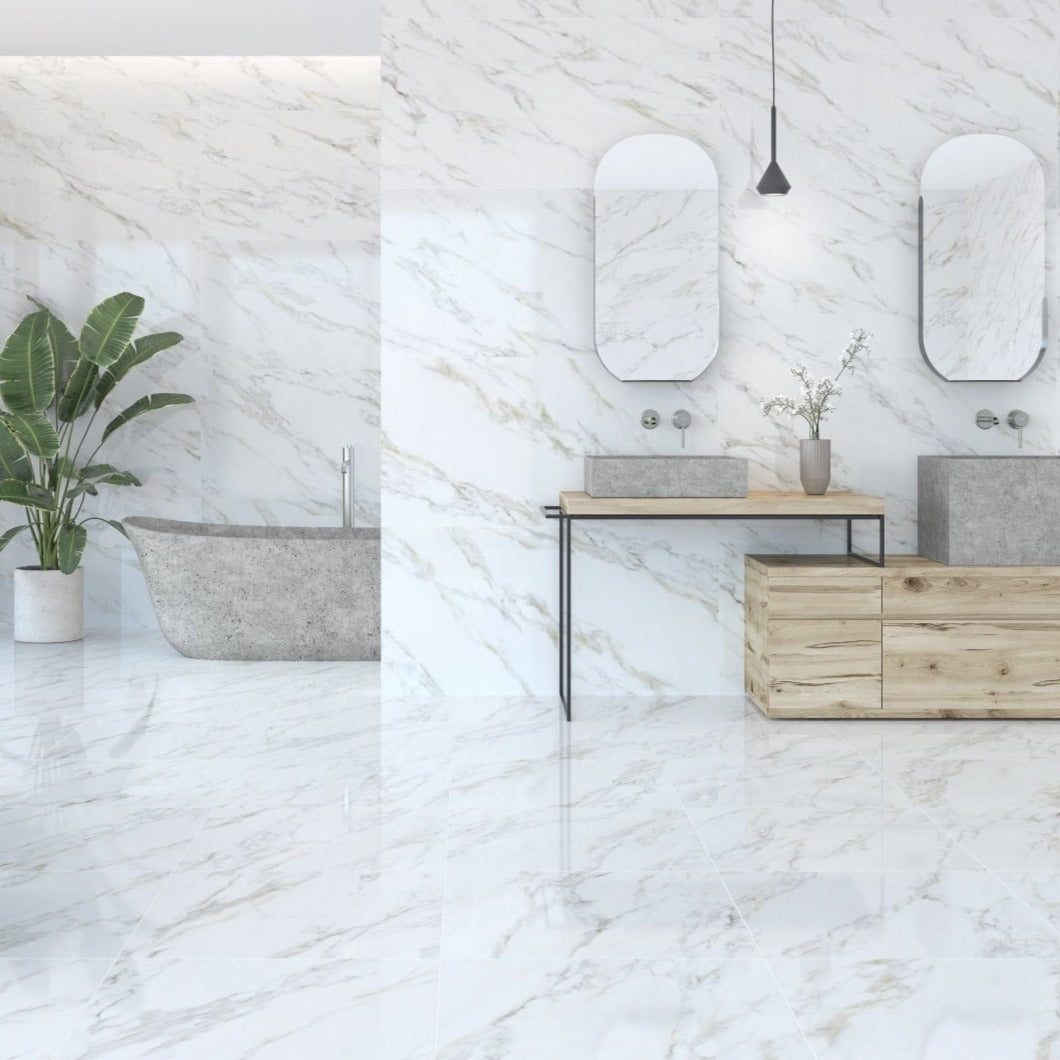Calacatta Gold porcelain tile with a white marble design, for floors and walls. Made in Spain, installed in a room.