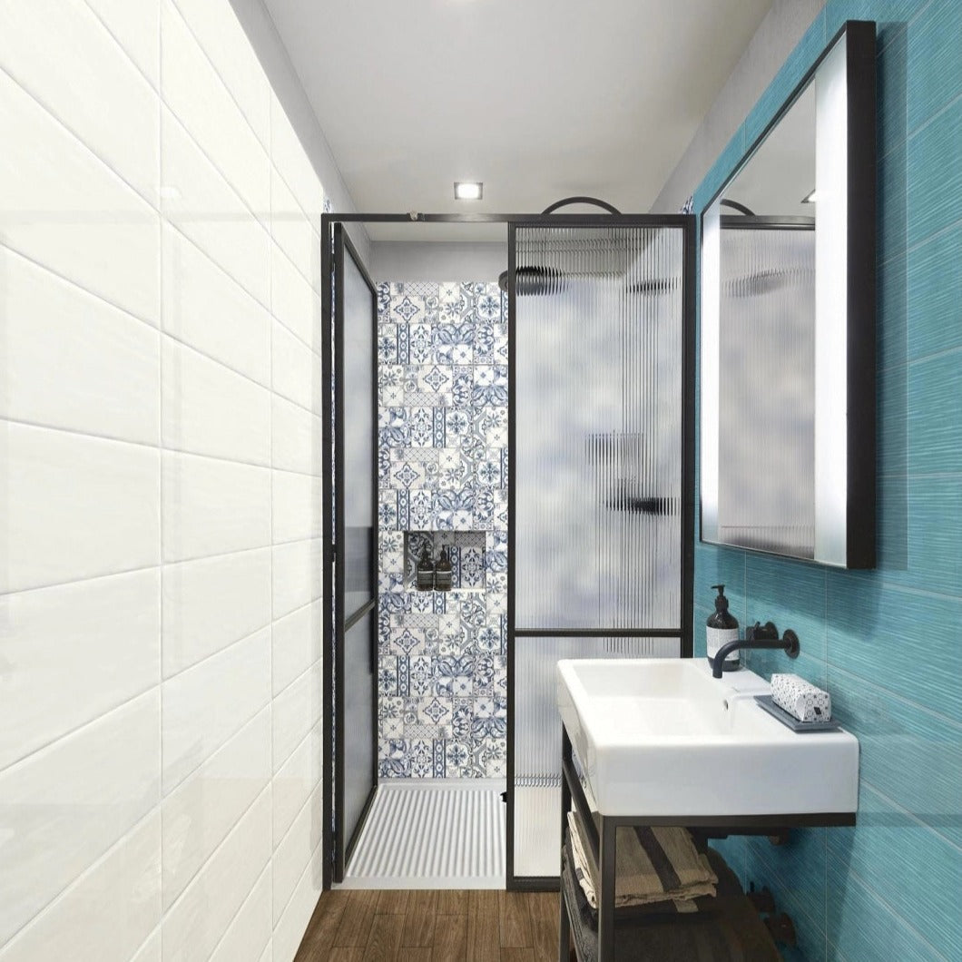 Candy Oceano glossy ceramic tile with a light blue design, for walls. Made in Spain, installed on a bathroom wall.