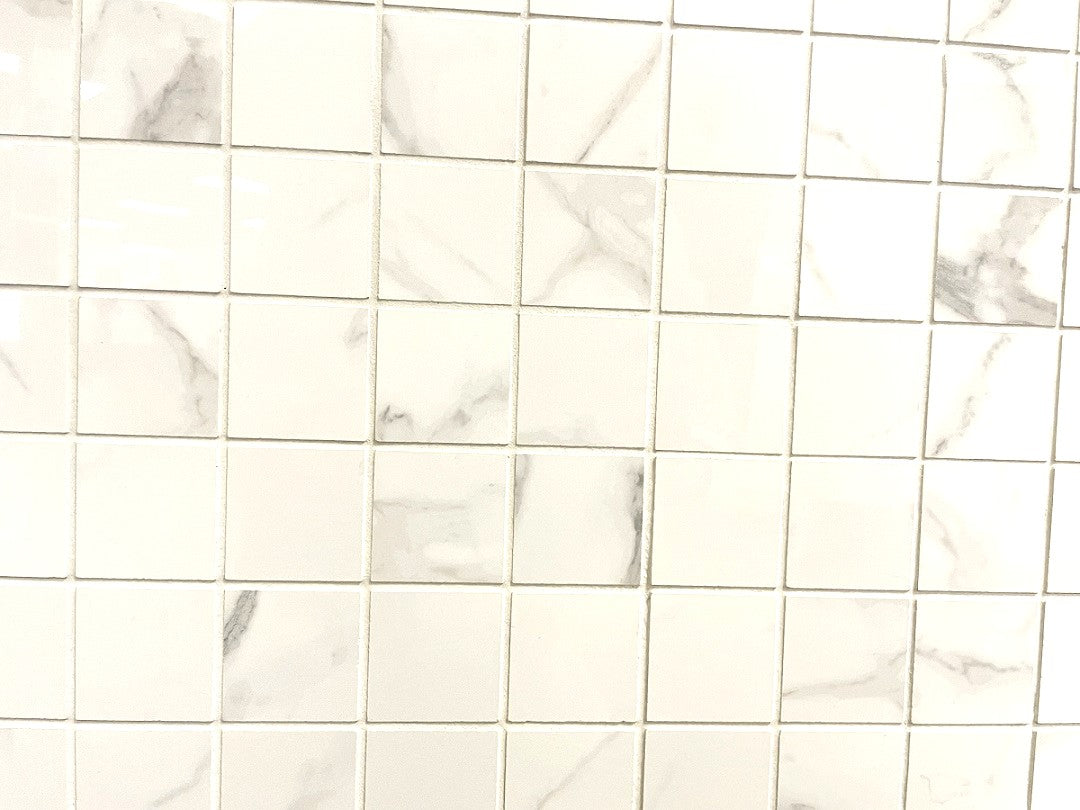 Carrara Royale polished porcelain tile in a white marble style, for floors and walls. In a square mosaic size.