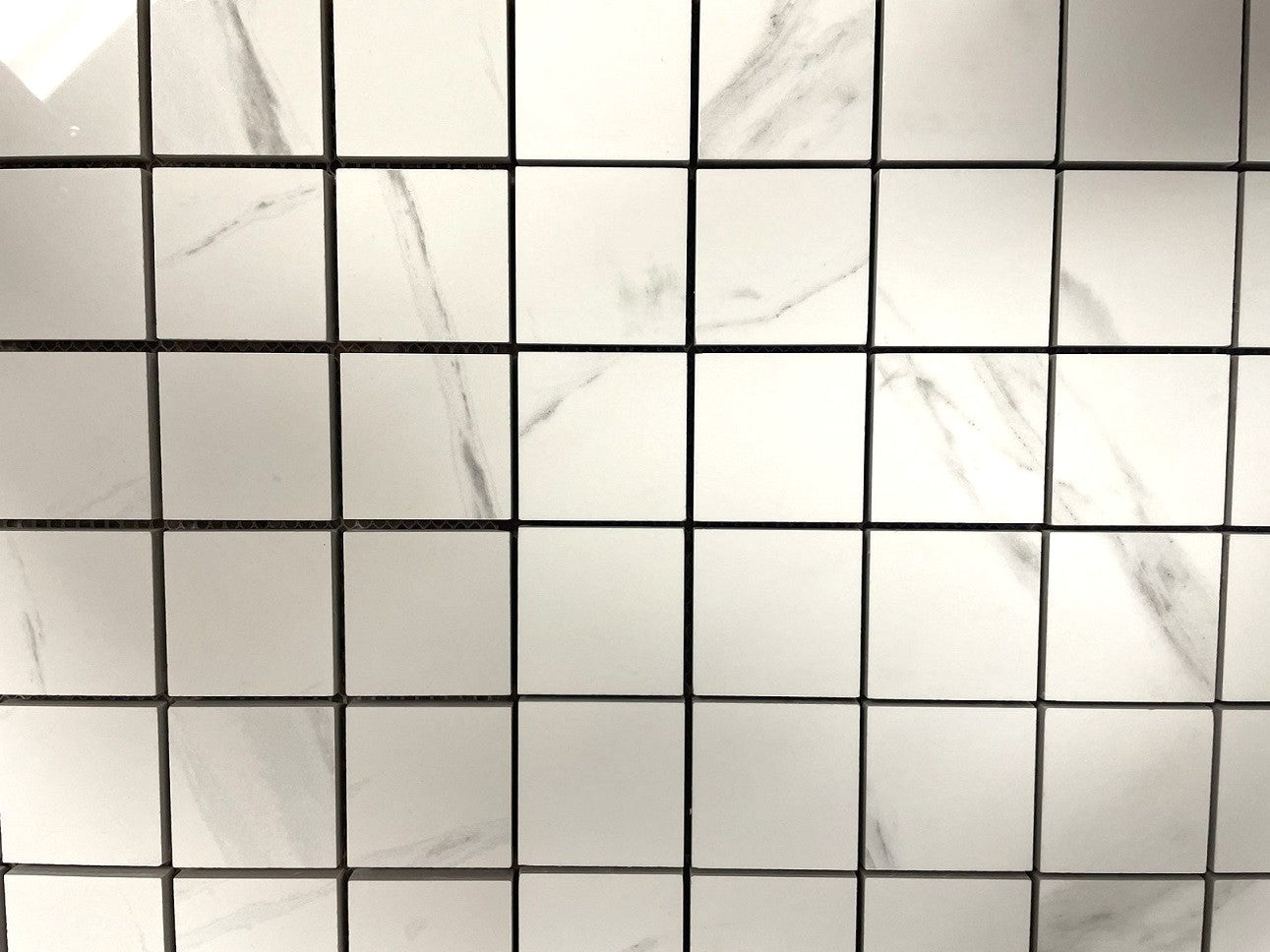 Carrara Striscia polished porcelain mosaic with a white marble design, for floors and walls. In a 2x2" square size.