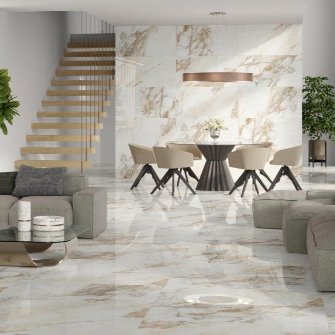 Calacatta Gold polished porcelain tile with a white and gold marble design, for floors and walls. Installed in a room.