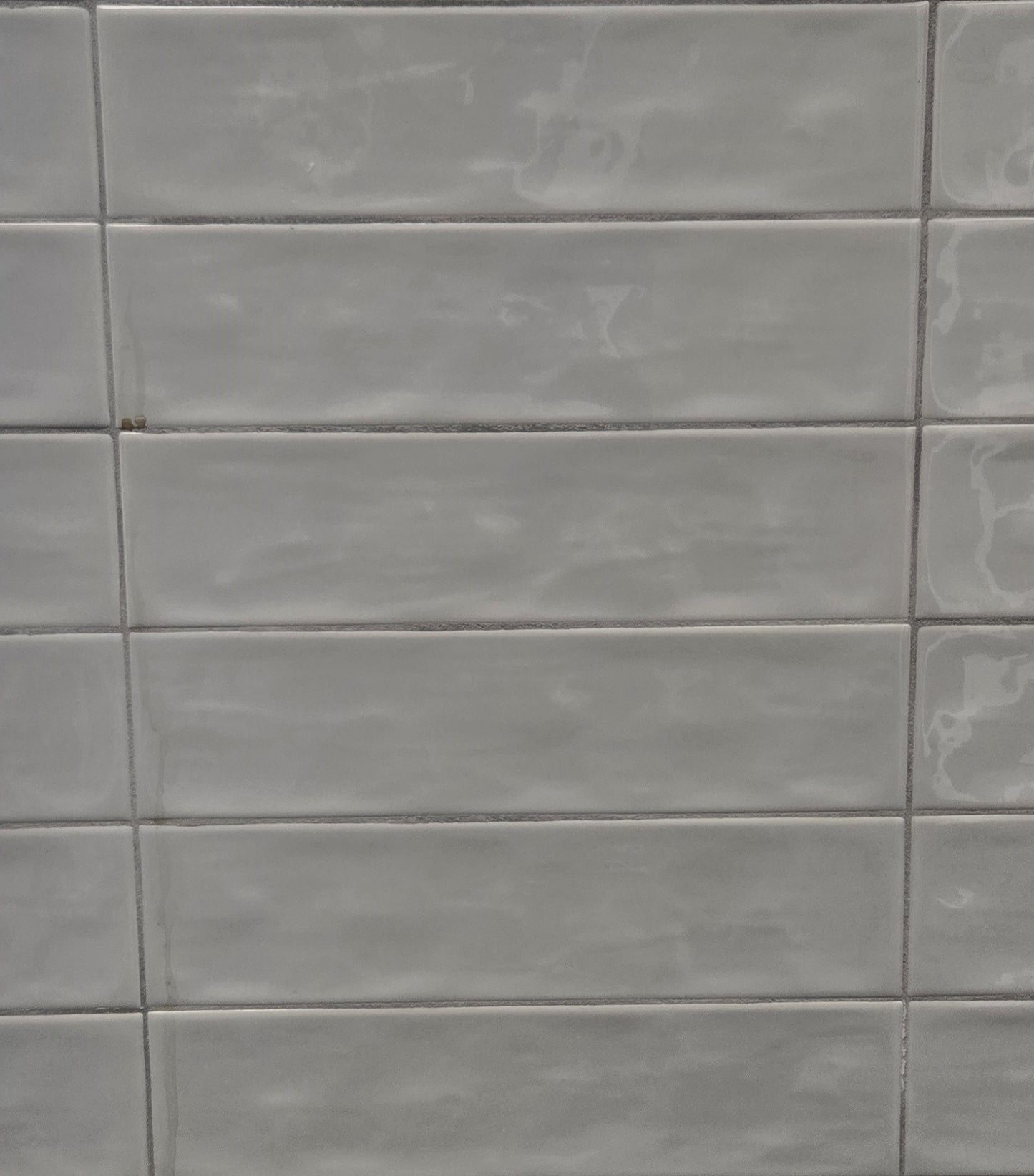 Dazzle Mist glossy ceramic subway tile with a light grey wavy artisan style for walls. In a 3x12" size.