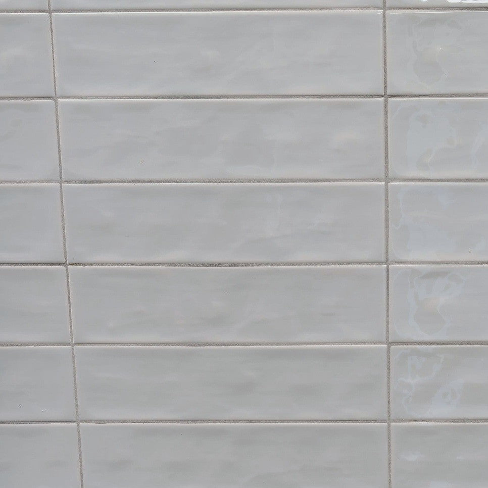 Dazzle Mist glossy ceramic subway tile with a light grey wavy artisan style for walls. In a 3x12" size.