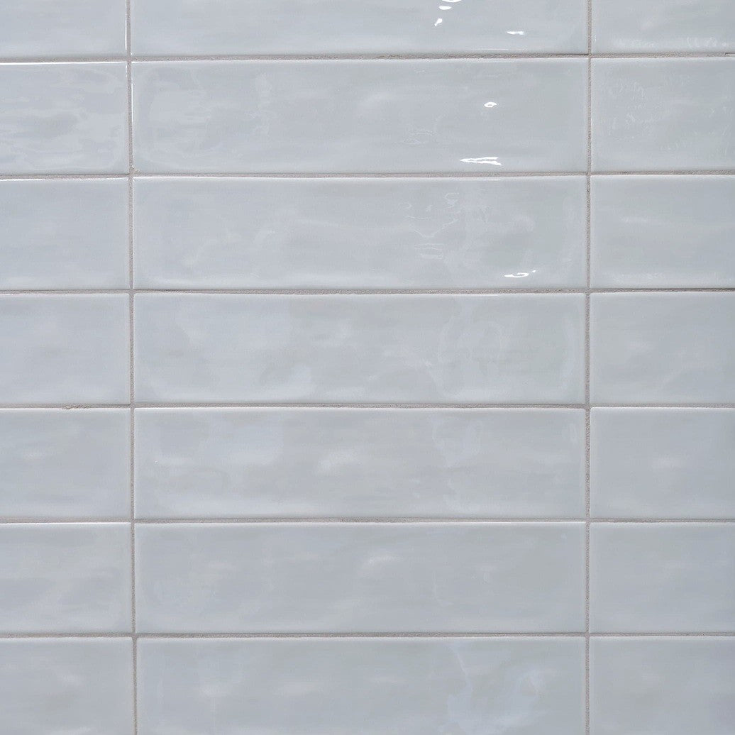 Dazzle Smoke glossy ceramic subway tile with a light blue wavy artisan style for walls. In a 3x12" size.