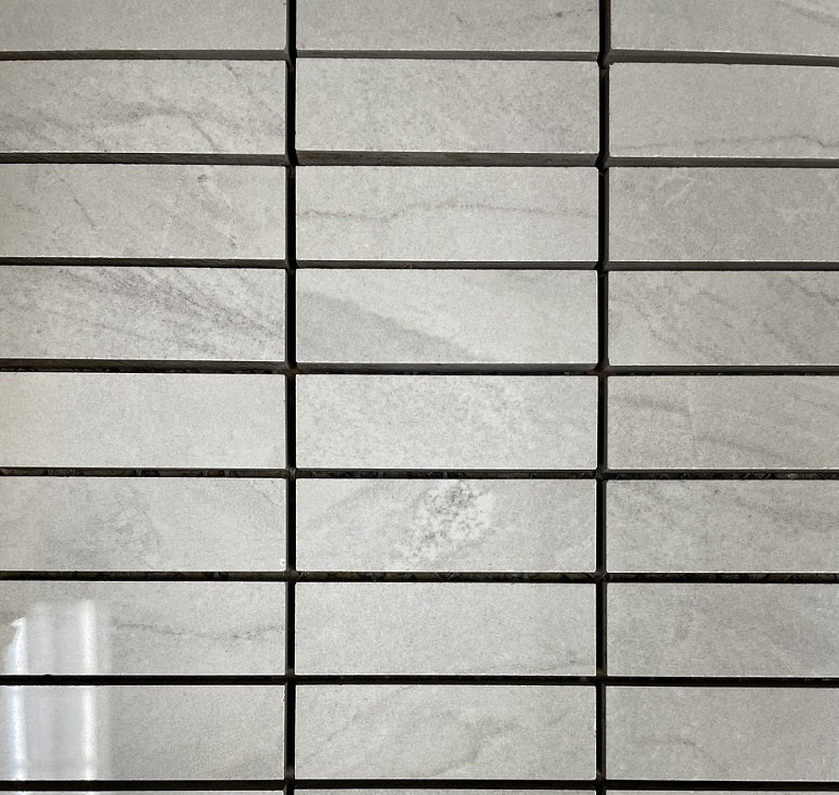 Lazio Mist polished porcelain tile with a grey stone design, for floors and walls. In a 1x3" mosaic size.