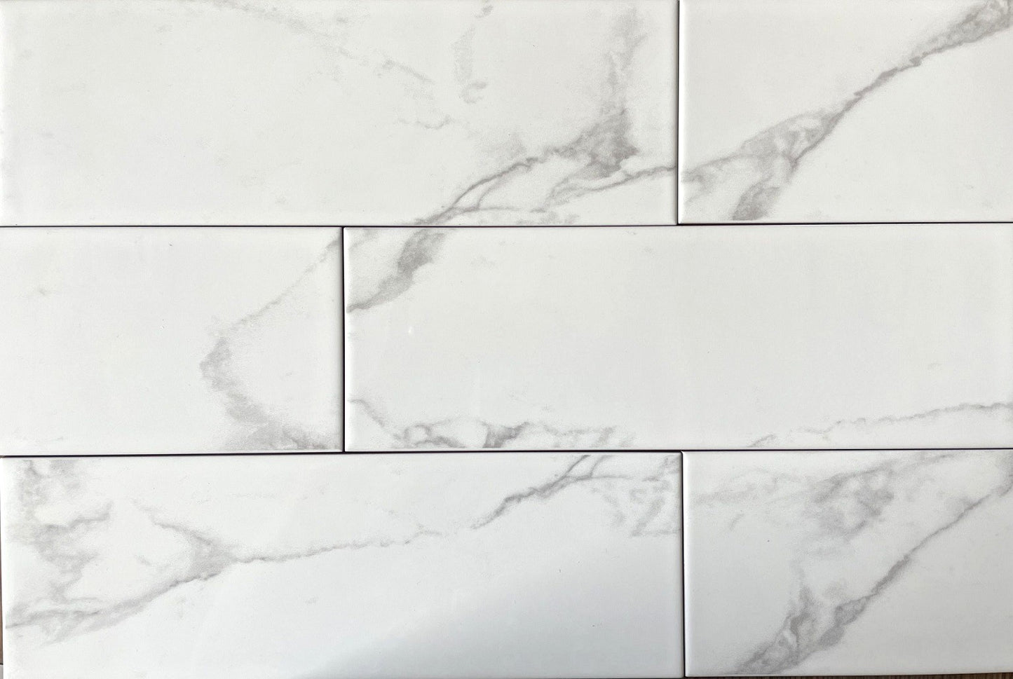 Liso Carrara white marble style glossy ceramic subway tile, for walls. Made in Spain, in a 4x12" size.