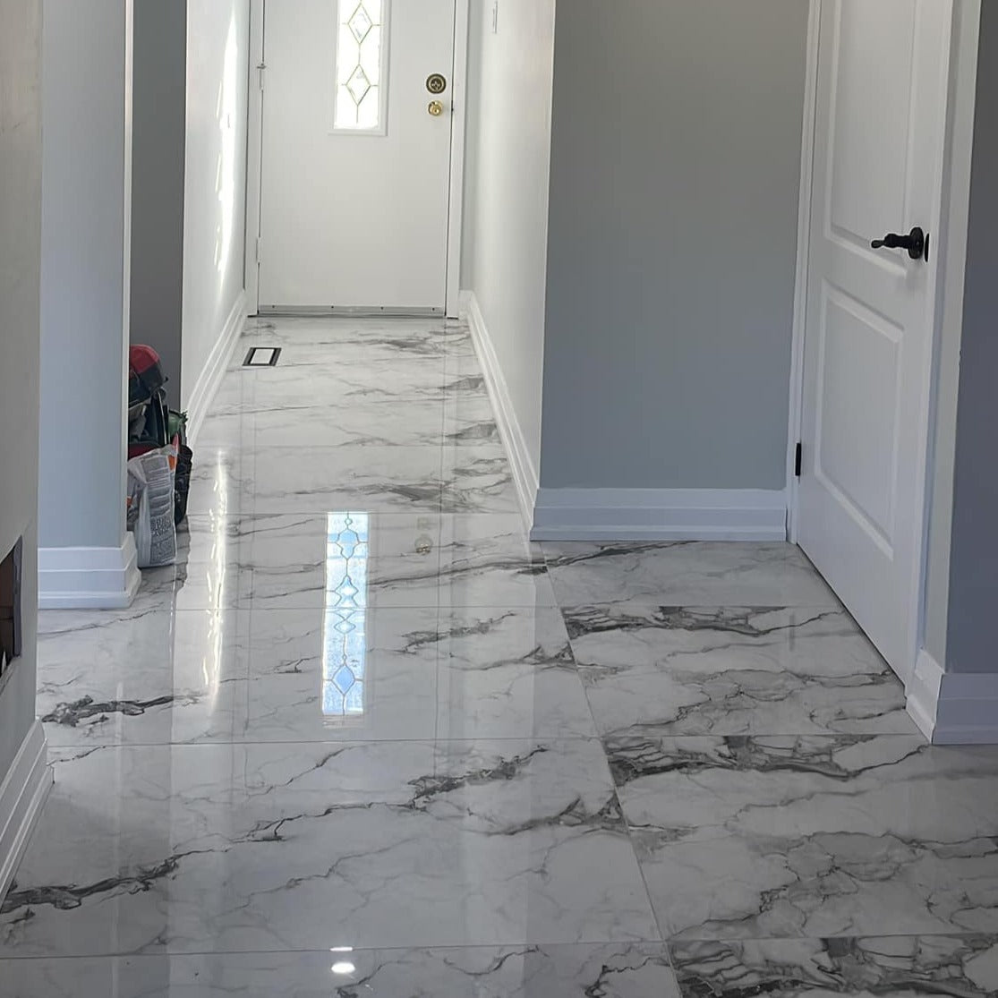 Marmo Divetente polished porcelain tile in a white and dark grey/black marble style. Installed on a floor.