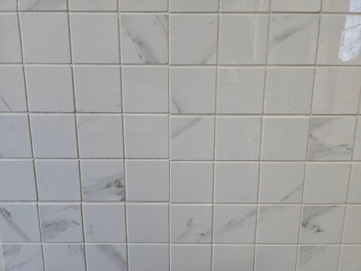 Marmo Julieta polished/matte porcelain tile in a soft white marble style, for floors and walls. In a square mosaic size.