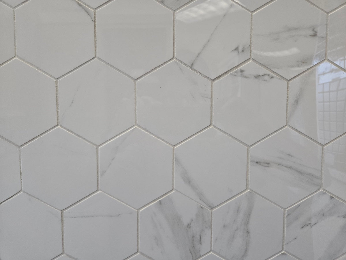 Marmo Julieta polished/matte porcelain tile in a soft white marble style, for floors and walls. In a hexagon mosaic.