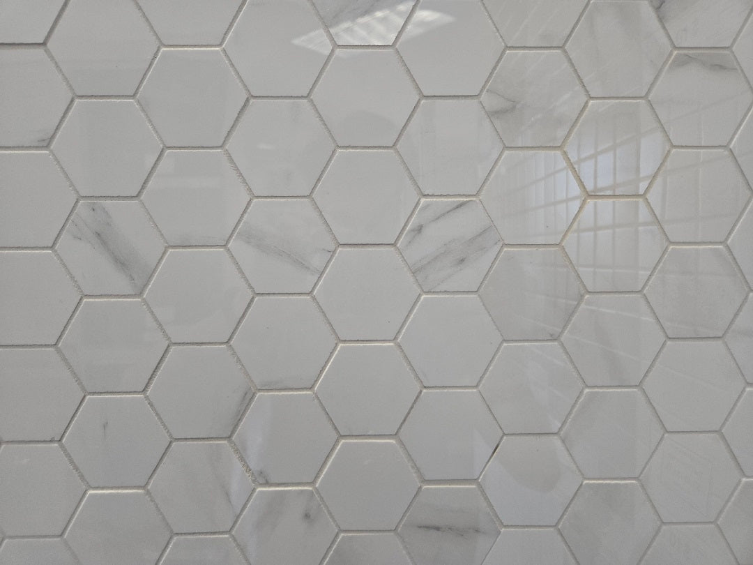 Marmo Julieta polished/matte porcelain tile in a soft white marble style, for floors and walls. In a hexagon mosaic.