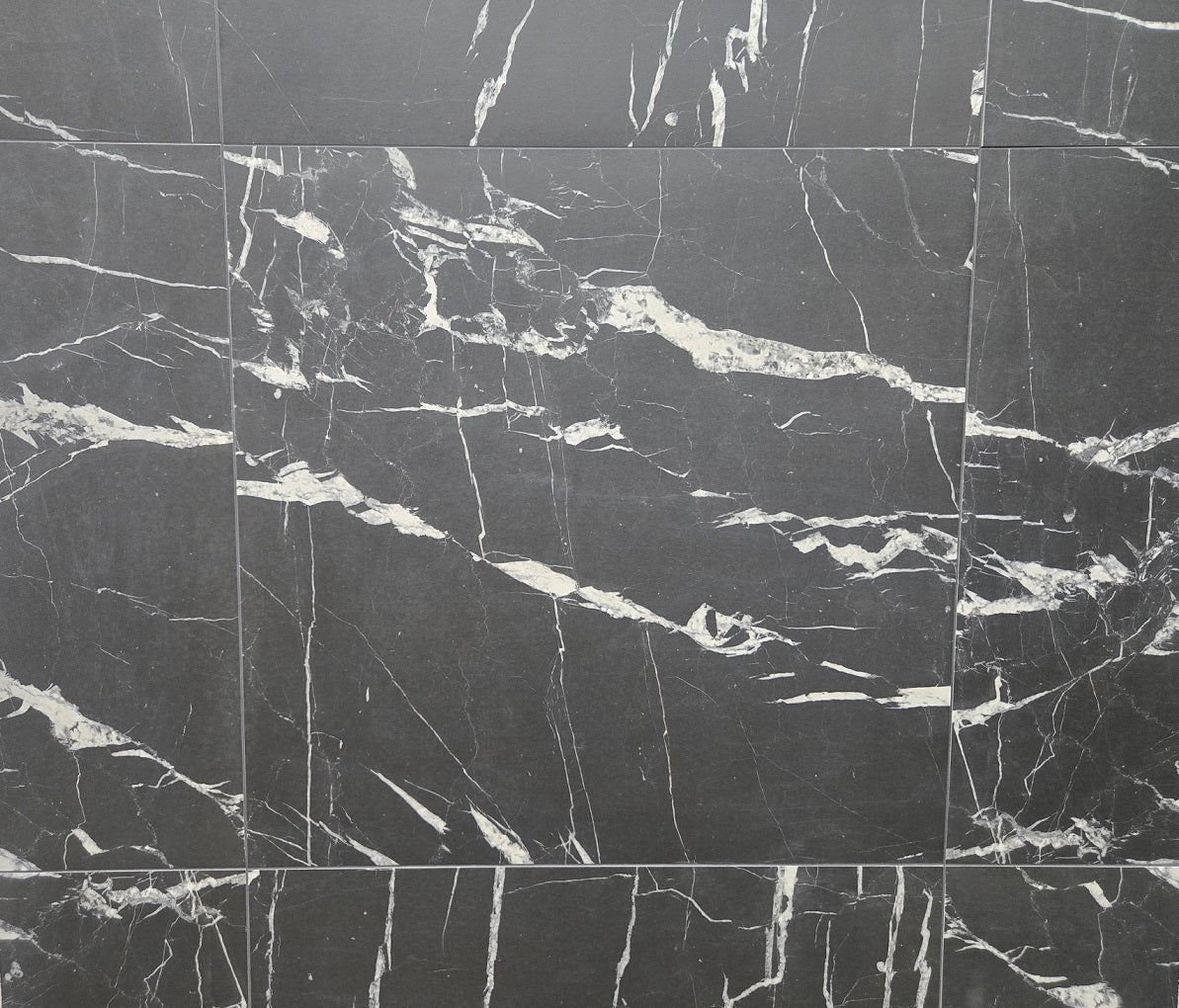Marquina matte porcelain tile with a black and busy white vein pattern, for floors and walls. In a 24x24" size.