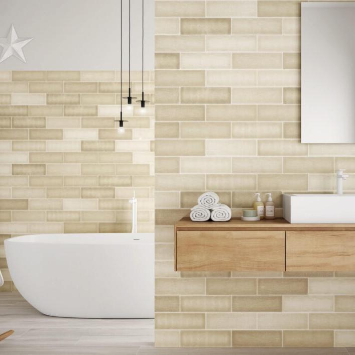 Mediterraneo Beige contemporary style glossy subway tile with varying designs. Installed on a bathroom walls.