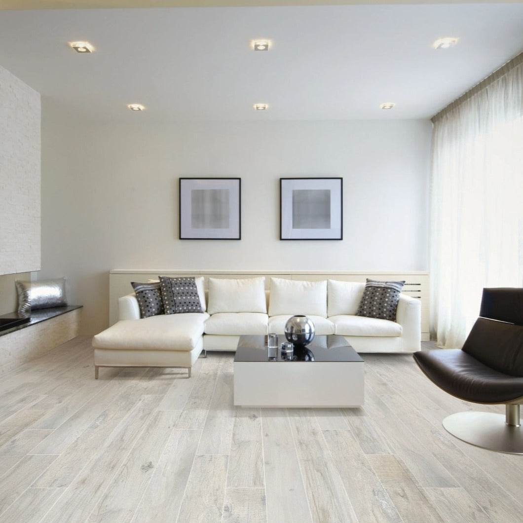 Memory Bianco matte porcelain tile with a white wood design, for floors and walls. Made in Italy, installed in a room.