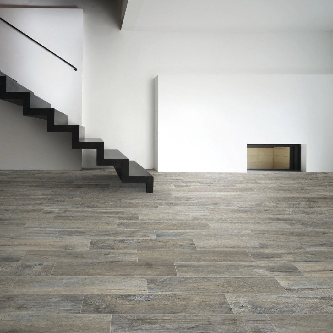 Memory Grigio matte porcelain tile with a grey wood design, for floors and walls. Made in Italy, installed in a room.