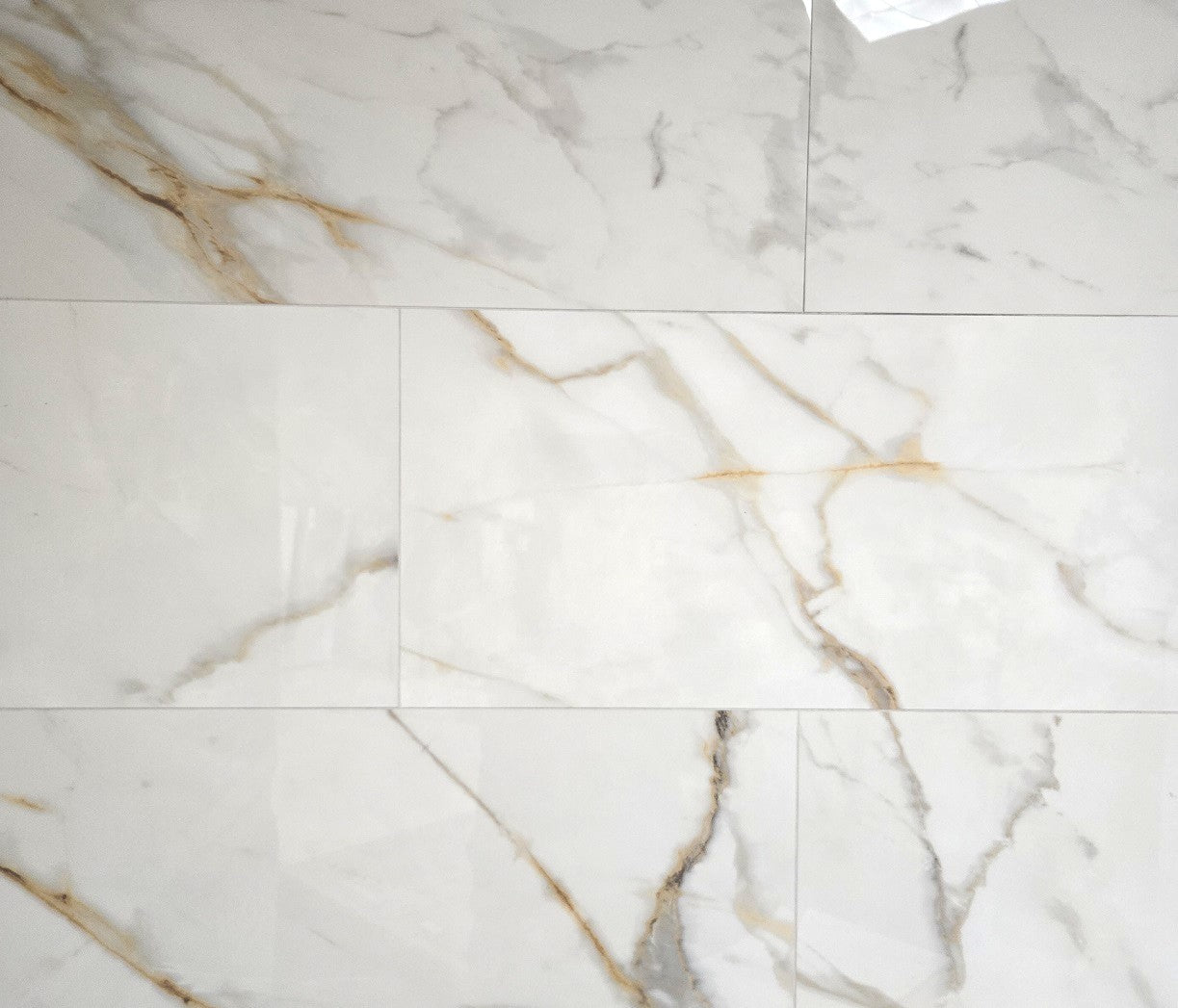 Miami Gold polished porcelain tile with a white, gold, and silver marble style, for floors and walls. In a 12x24" size.