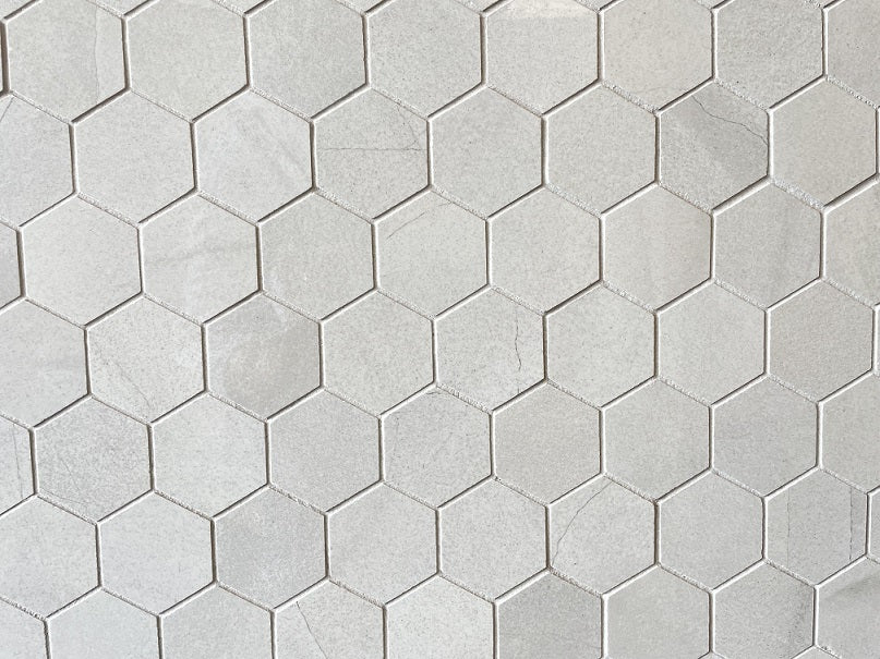 Moondust Pearl polished porcelain mosaic with a light grey marble style, for floors and walls. In a 2" hexagon size.