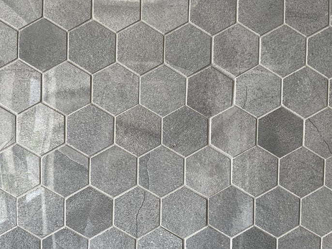Moondust Shadow polished porcelain mosaic with a dark grey marble style, for floors and walls. In a 2" hexagon size.