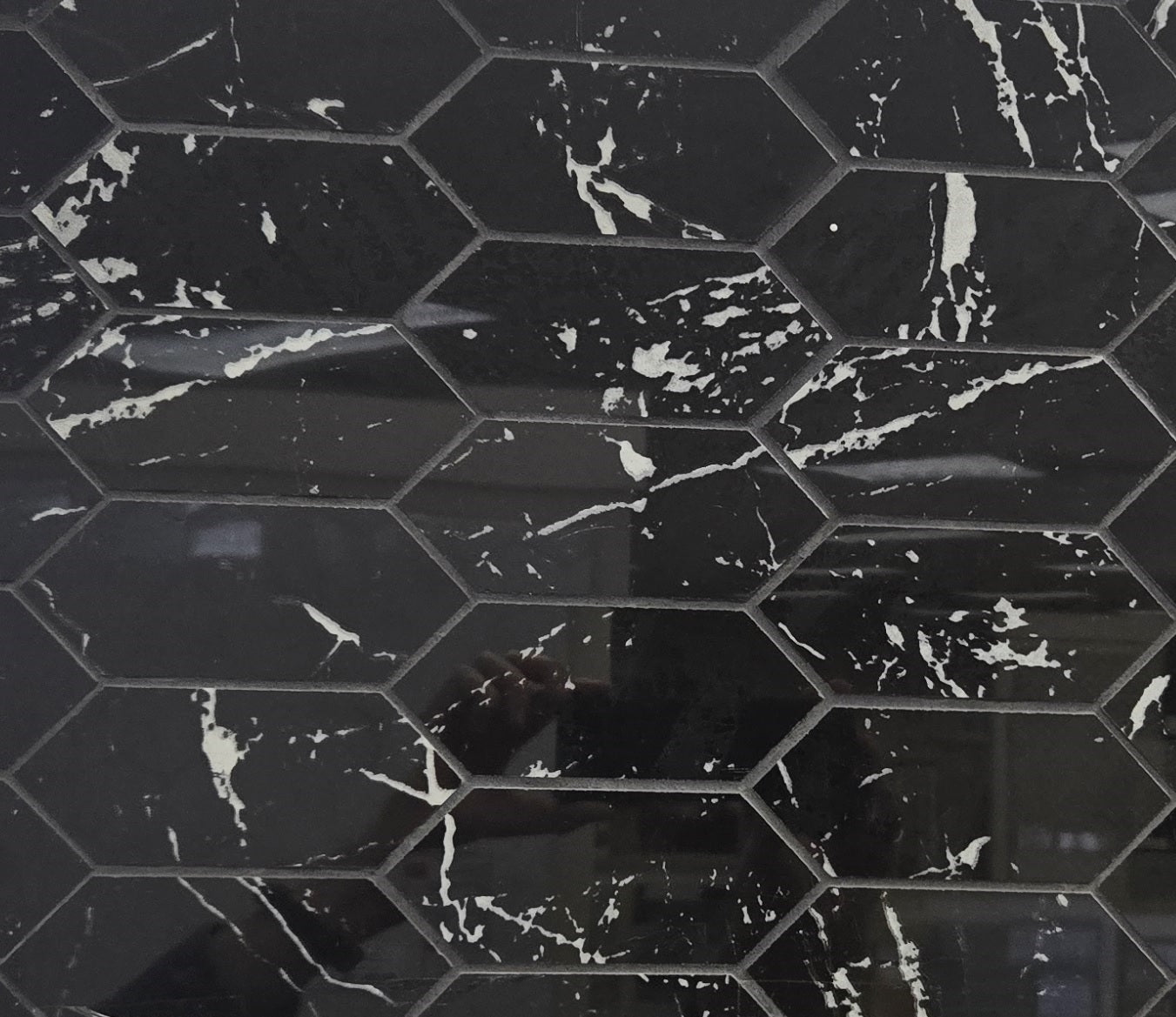 Nero Marquina polished porcelain tile with black marble design, for floors and walls. In an elongated hexagon mosaic.