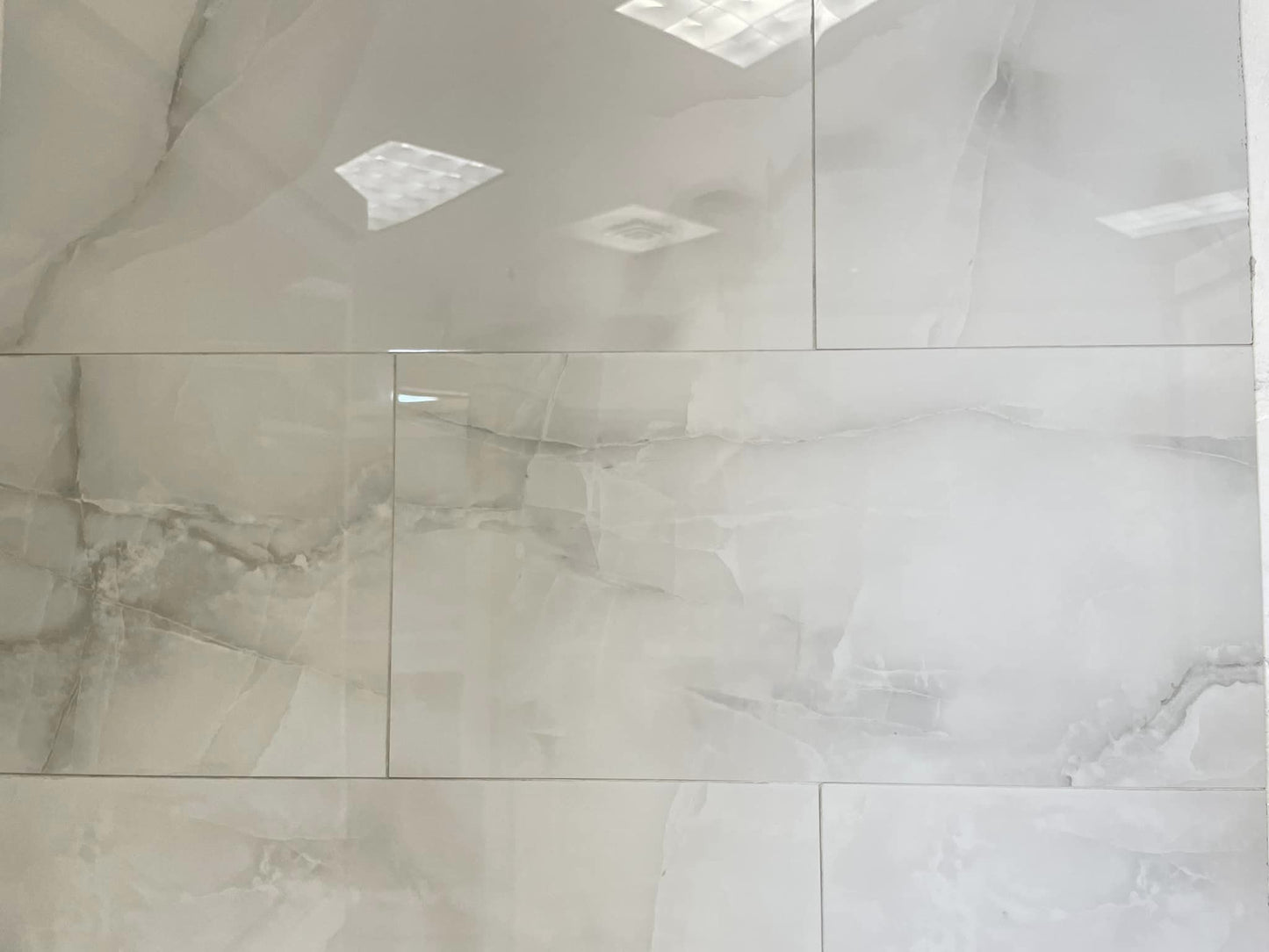Onice Grigio polished porcelain tile with a grey onyx design, for floors and walls. In a 12x24" size.