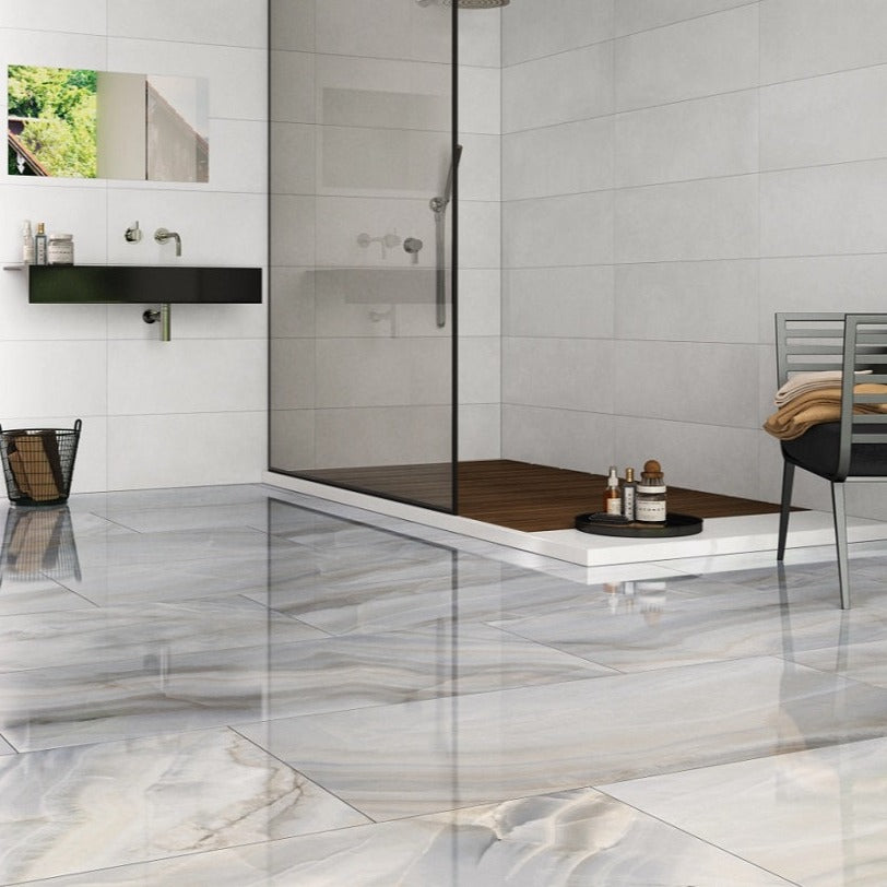 Onice Perla glossy porcelain tile with a grey onyx design, for walls. Made in Spain, installed in a room.
