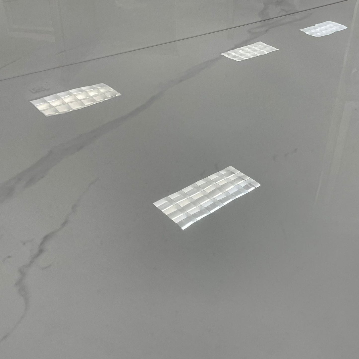 Parthenon polished porcelain tile with a white marble design, for floors and walls. A close up of the tile.