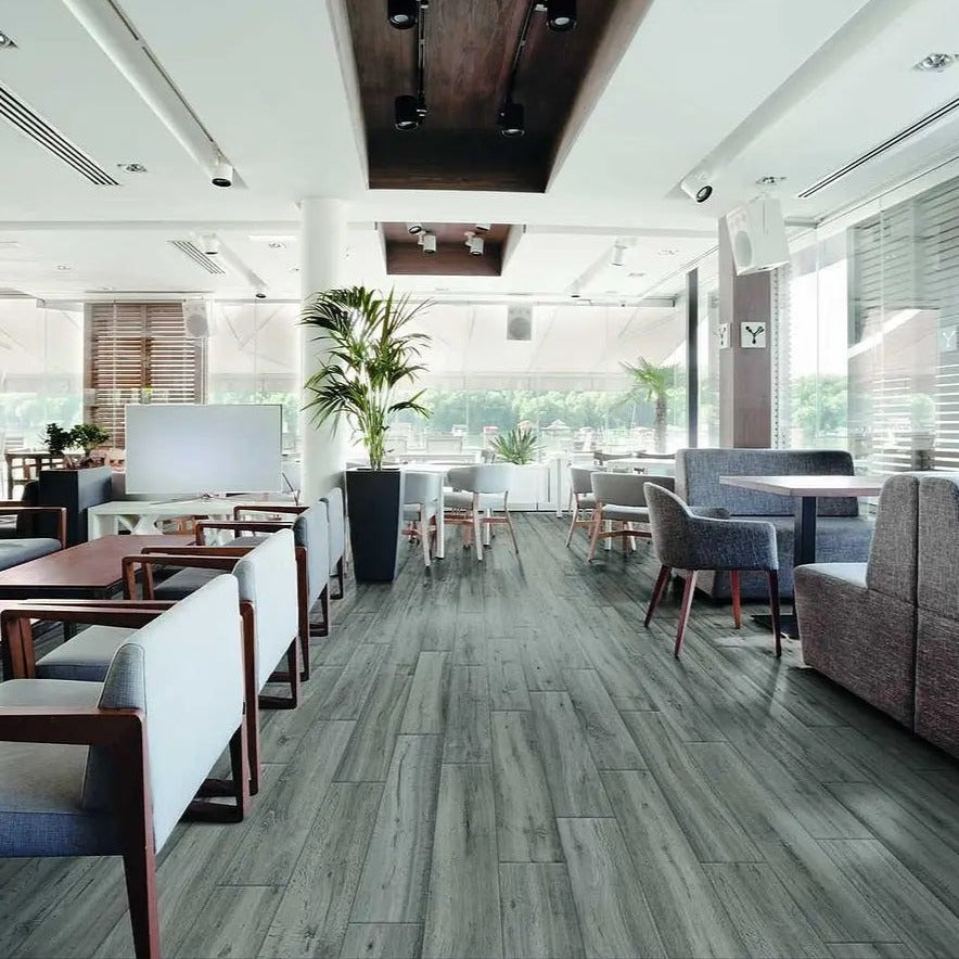 Travekheart Grey matte porcelain tile with a wood design, for floors and walls. Made in Italy, installed in a room.