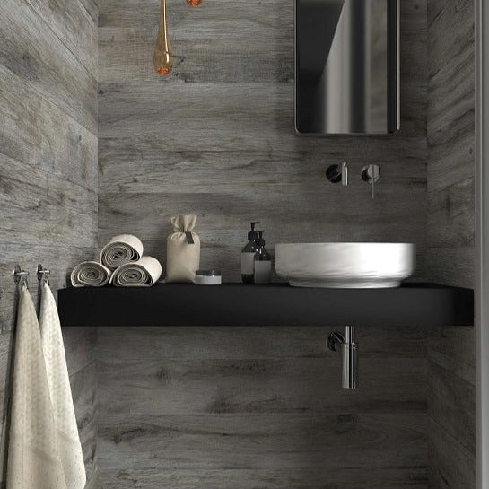 Vintage Grigio matte porcelain tile with a grey wood design, for floors and walls. Made in Italy, installed in a room.
