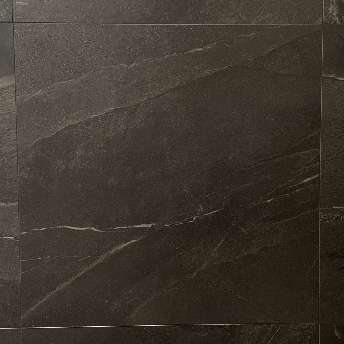 Alaska Granite matte finish porcelain tile with a black stone design, for floors and walls. In a 24x24" size.