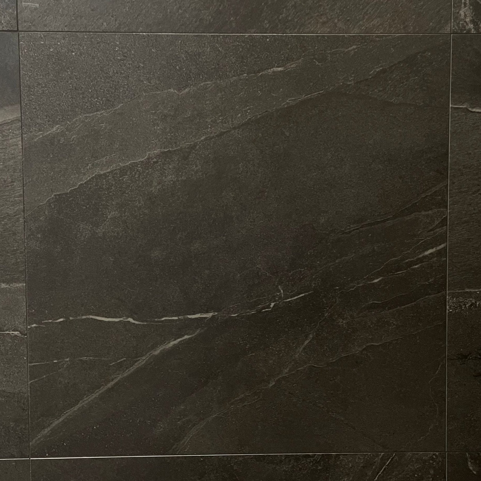 Alaska Granite matte finish porcelain tile with a black stone design, for floors and walls. In a 24x24" size.
