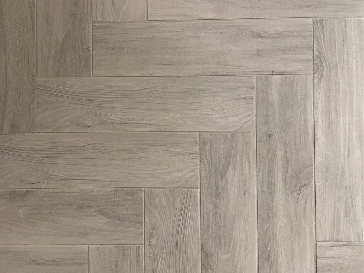 Bark Grigio matte porcelain tile with a grey wood design, for floors and walls. Made in Italy, installed in a room.