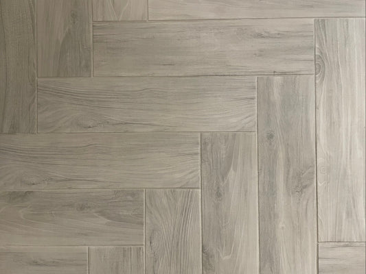 Bark Grigio matte porcelain tile with a grey wood design, for floors and walls. Made in Italy, installed in a room.