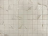 Calacatta Oro polished porcelain tile with a white/gold marble design, for floors and walls. In a 2x2" square mosaic.