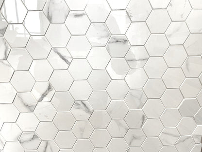 Carrara Royale polished porcelain tile in a white marble style, for floors and walls. In a small hexagon mosaic.