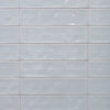 Dazzle Smoke glossy ceramic subway tile with a light blue wavy artisan style for walls. In a 3x12" size.