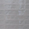 Dazzle Smoke glossy ceramic subway tile with a grey wavy artisan style for walls. In a 3x12" size.