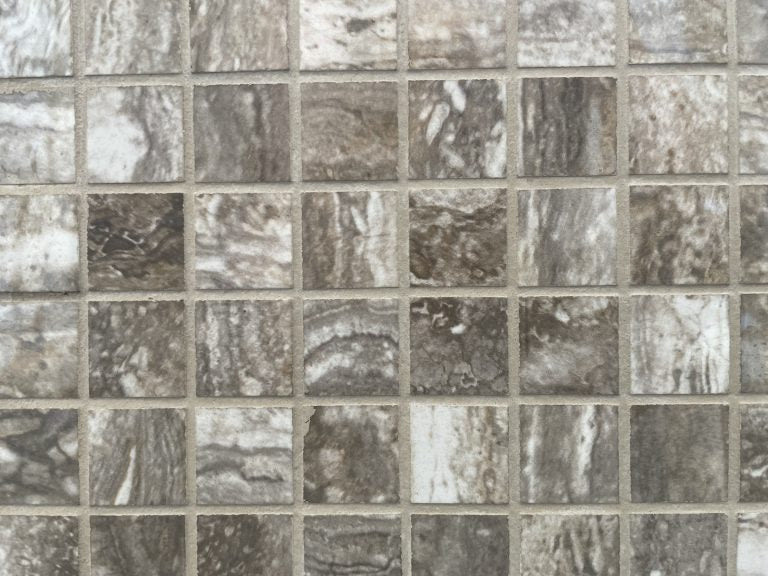 Ferrara Noce polished porcelain tile with a brown stone design, for floors and walls. In a 1x1" square mosaic size.