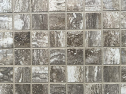 Ferrara Noce polished porcelain tile with a brown stone design, for floors and walls. In a 1x1" square mosaic size.