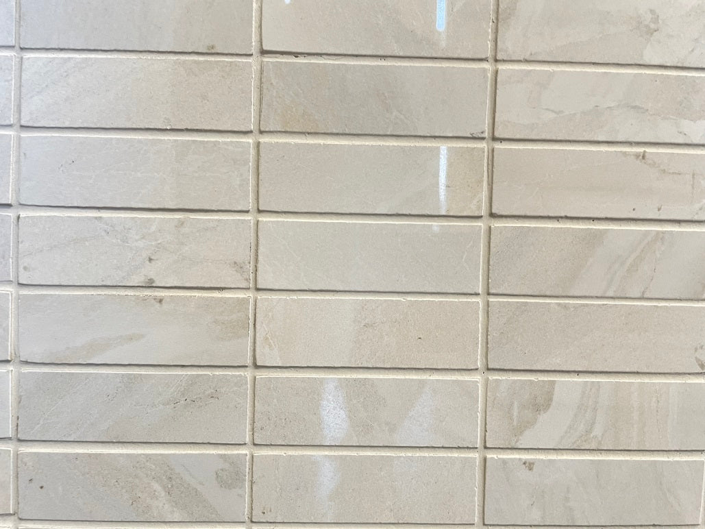 Lazio Ivory polished porcelain tile with a stone design, for floors and walls. In a 1x3" mosaic size.