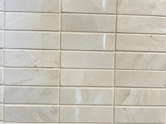 Lazio Ivory polished porcelain tile with a stone design, for floors and walls. In a 1x3" mosaic size.