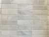 Lazio Pearl polished porcelain tile with a grey stone design, for floors and walls. In a 1x3" mosaic size.