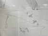 Carrara Bianco polished porcelain tile with a white marble design, for floors and walls. In a 14x28" size.