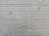 Marmo Julieta polished/matte porcelain tile in a soft white marble style. In a random strip mosaic size.
