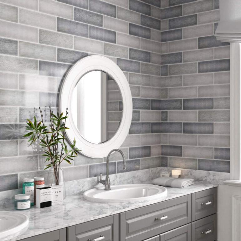 Mediterraneo Gris contemporary style glossy grey subway tile with varying designs. Installed on a vanity backsplash.