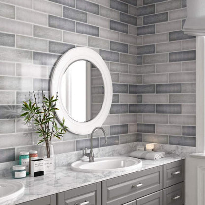 Mediterraneo Gris contemporary style glossy grey subway tile with varying designs. Installed on a vanity backsplash.