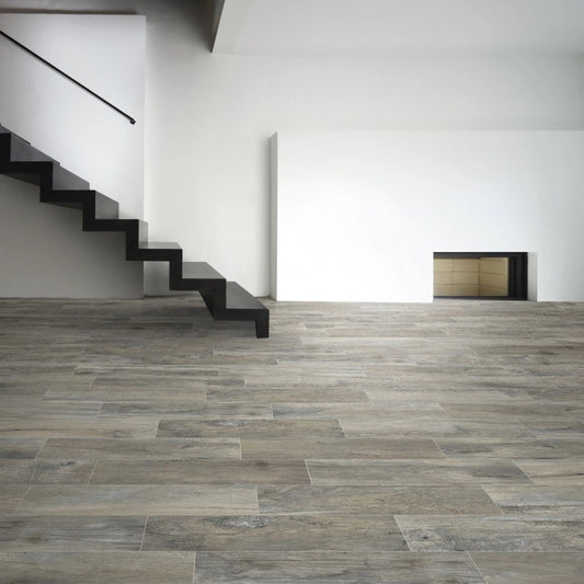 Memory Grigio matte porcelain tile with a grey wood design, for floors and walls. Made in Italy, installed in a room.